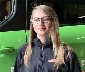 Female SERVPRO Technician in fromt of a SERVPRO vehicle